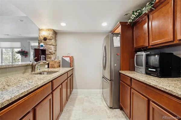 a kitchen with stainless steel appliances granite countertop a sink and a refrigerator