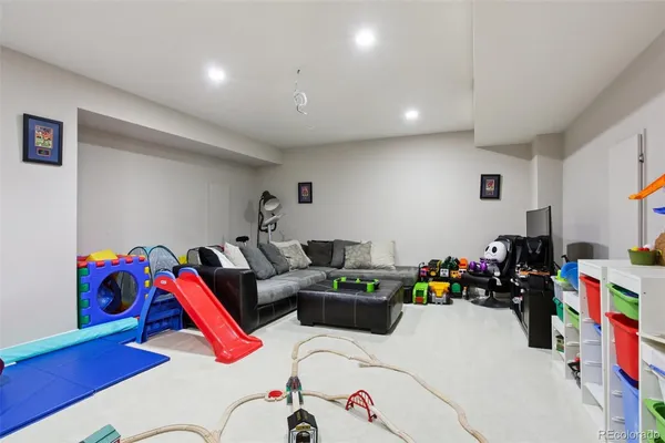 a living room with lots of furniture and baby bed