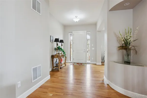 a hallway with wooden floor and a potted plant