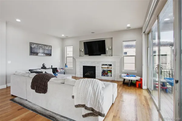 a living room with furniture a flat screen tv and a fireplace
