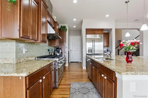 a kitchen with kitchen island granite countertop a sink stove and cabinets