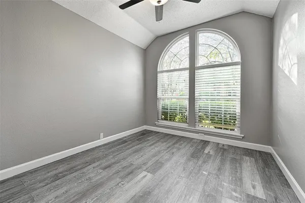 an empty room with a window and wooden floor