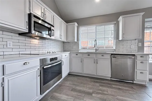 a kitchen with granite countertop cabinets stainless steel appliances and a sink