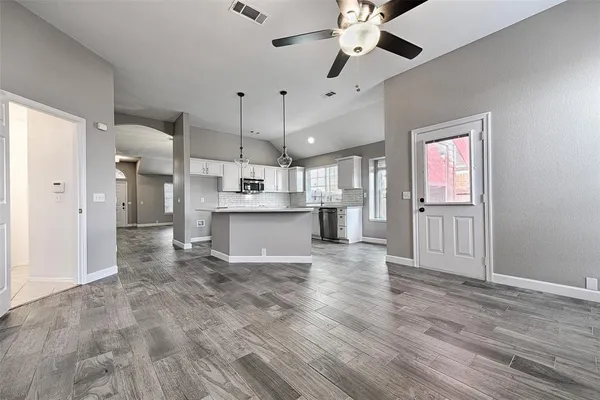 a view of a kitchen with refrigerator microwave and wooden floor