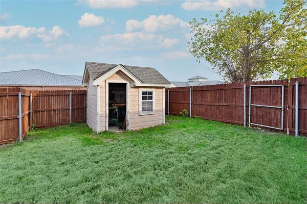 a view of a backyard with potted plants and large tree