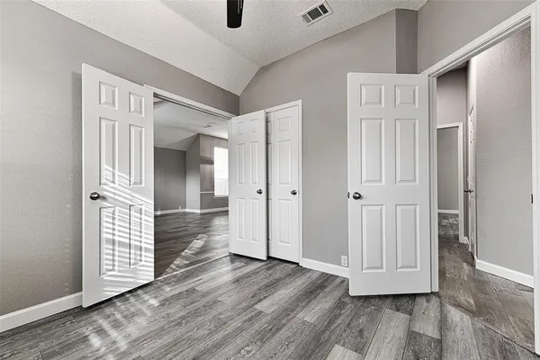 a view of empty room with wooden floor