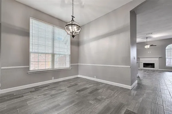 an empty room with chandelier and windows