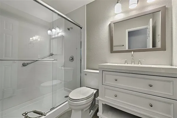a bathroom with a sink a toilet and shower
