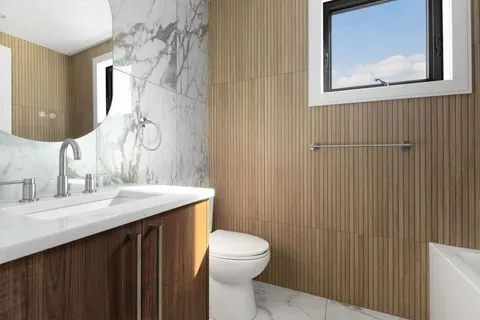 a bathroom with a granite countertop sink toilet and mirror