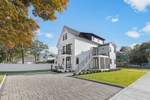 a view of a white house with a yard