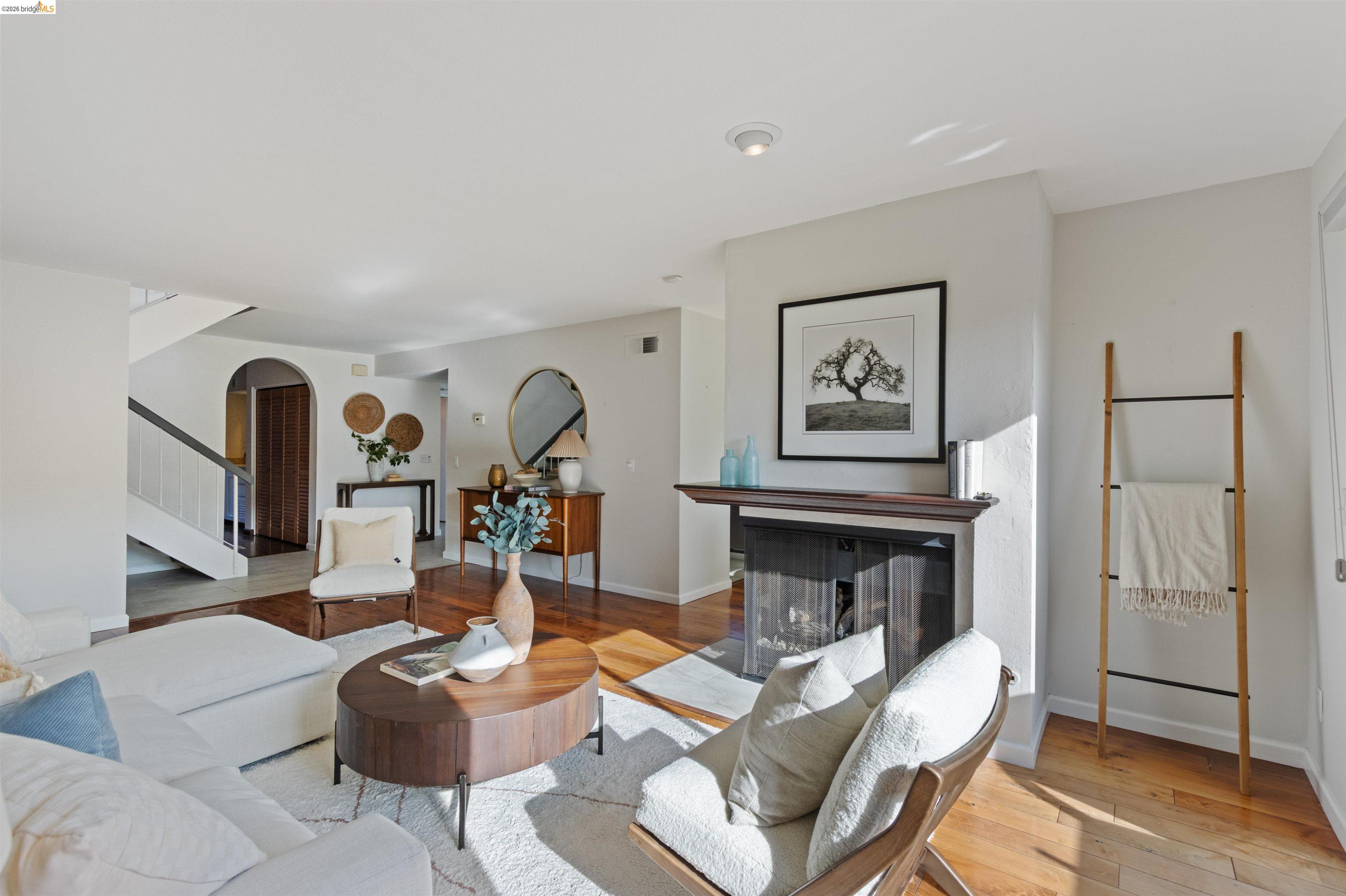 548 Queen's Road Alameda, CA 94501 - Photo 6 of 42 Living room with a multi sided fireplace, arched walkways, and wood-type flooring