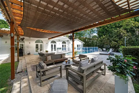 a roof deck with couches and wooden fence with potted plants