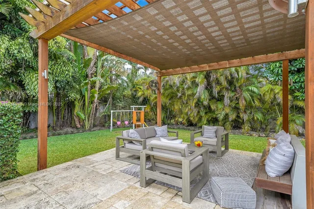 a view of a patio with a table and chairs next to a yard