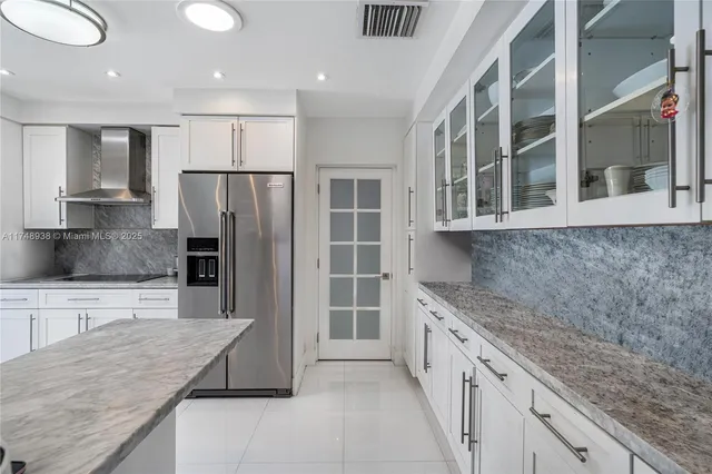a kitchen with stainless steel appliances granite countertop a refrigerator and a sink