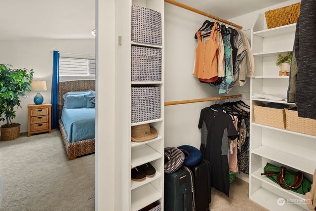 a view of walk in closet with clothes and shoes