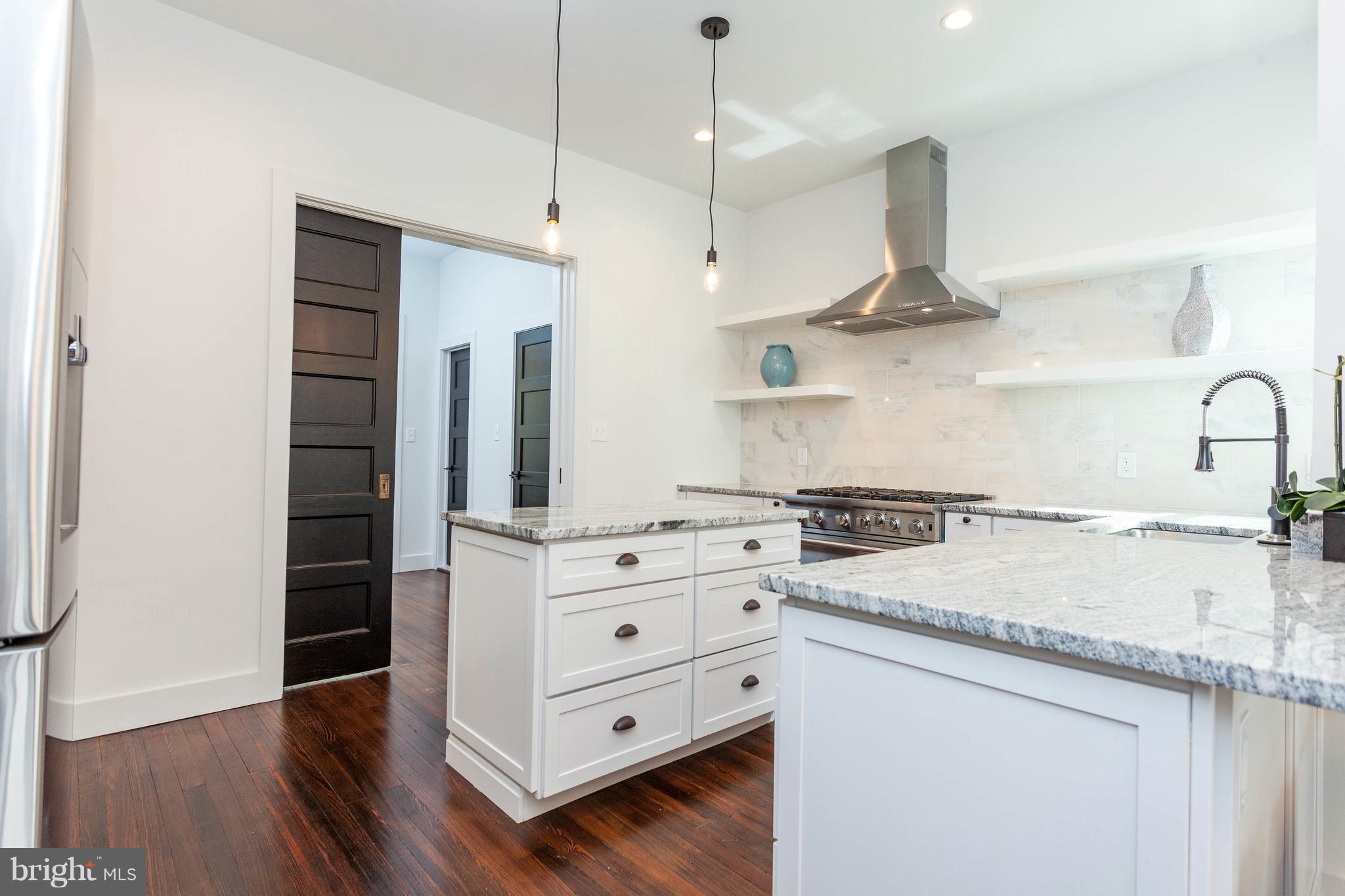 15 R Street Northeast, Unit A Washington, DC 20002 - Photo 4 of 25 a kitchen with stainless steel appliances granite countertop a sink a stove and a wooden floor
