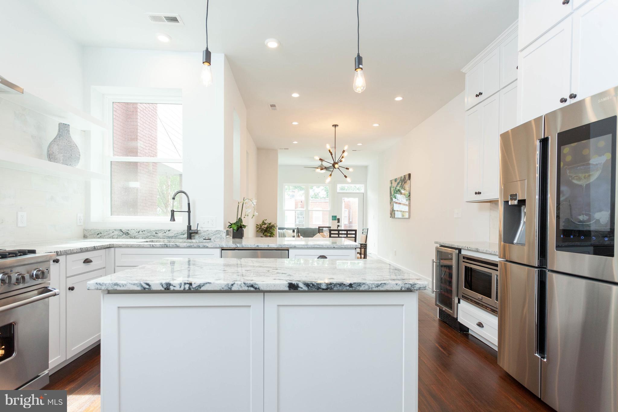 15 R Street Northeast, Unit A Washington, DC 20002 - Photo 5 of 25 a kitchen with stainless steel appliances granite countertop a sink a stove a refrigerator and island with wooden floor