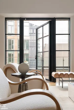 a bedroom with furniture and a large window