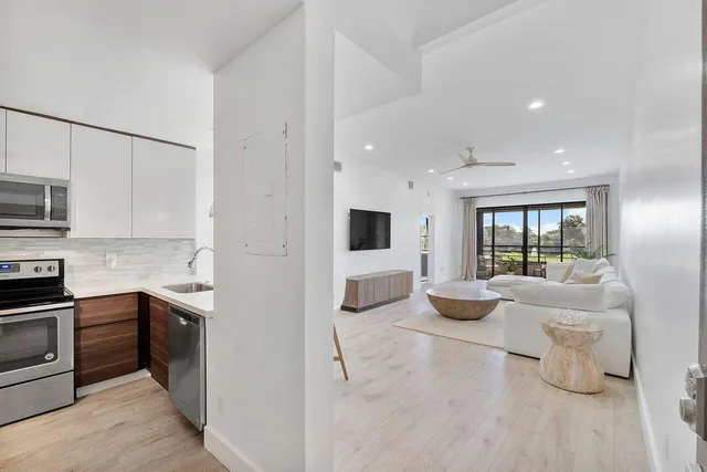 a kitchen with stainless steel appliances kitchen island granite countertop a sink and dishwasher a stove top oven with wooden floor