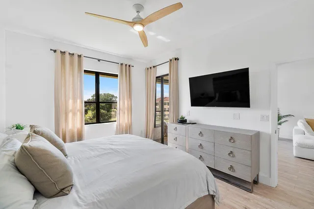a bedroom with a bed and a flat tv screen on dresser