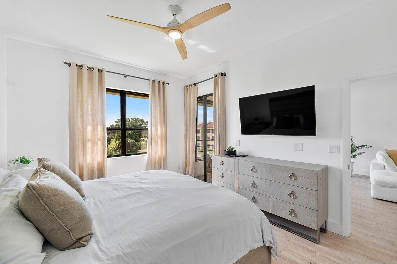 7508 La Paz Boulevard, Unit 304 Boca Raton, FL 33433 - Photo 16 of 44 a bedroom with a bed and a flat tv screen on dresser