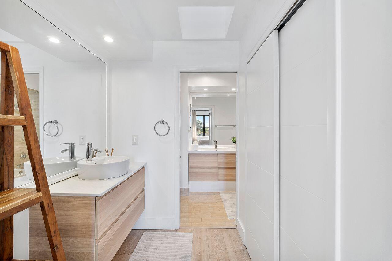 7508 La Paz Boulevard, Unit 304 Boca Raton, FL 33433 - Photo 17 of 44 a bathroom with a sink a mirror and a shower