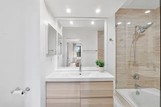 a bathroom with a bathtub shower sink and mirror