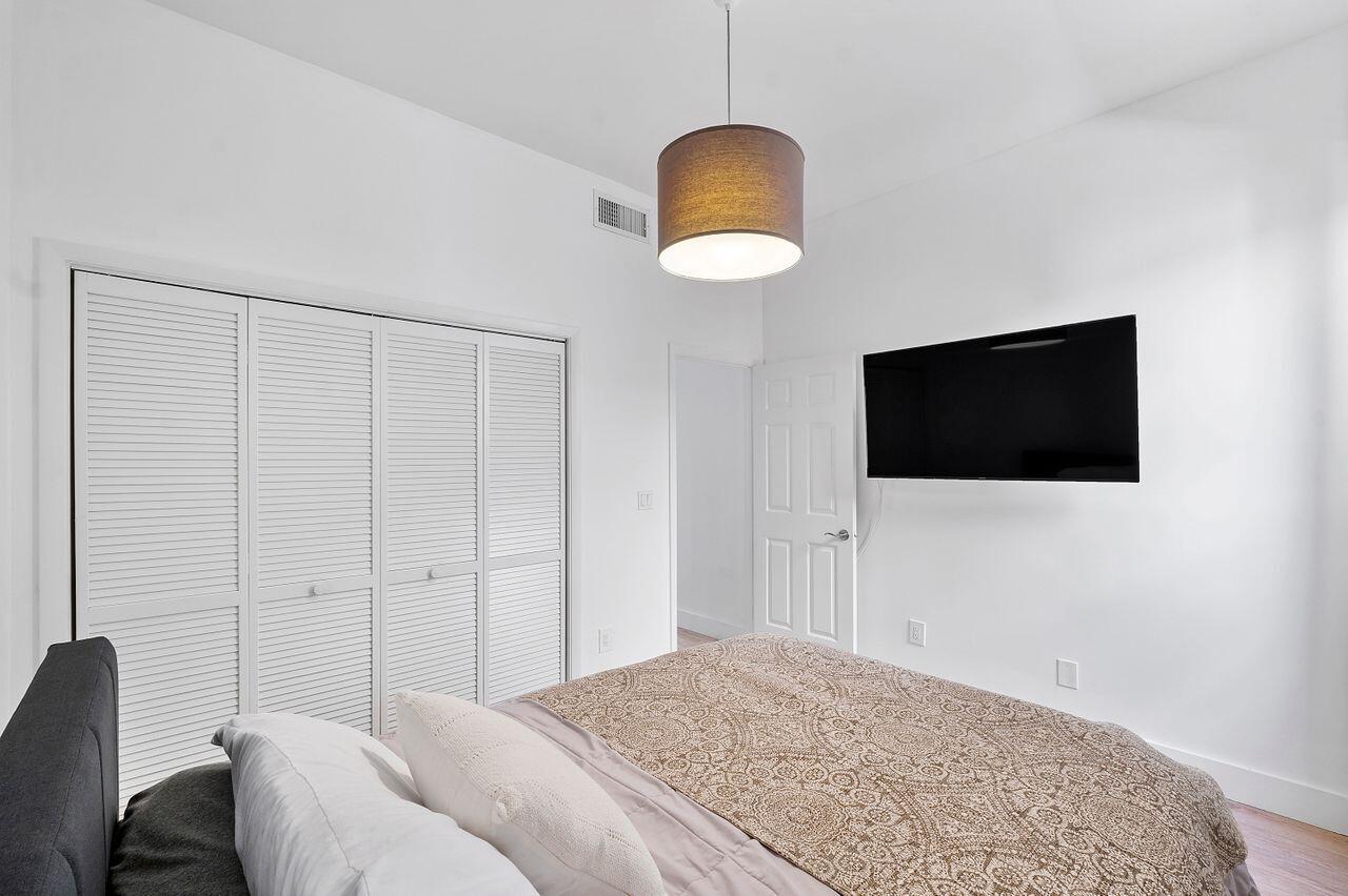 7508 La Paz Boulevard, Unit 304 Boca Raton, FL 33433 - Photo 22 of 44 a bedroom with a bed and a television