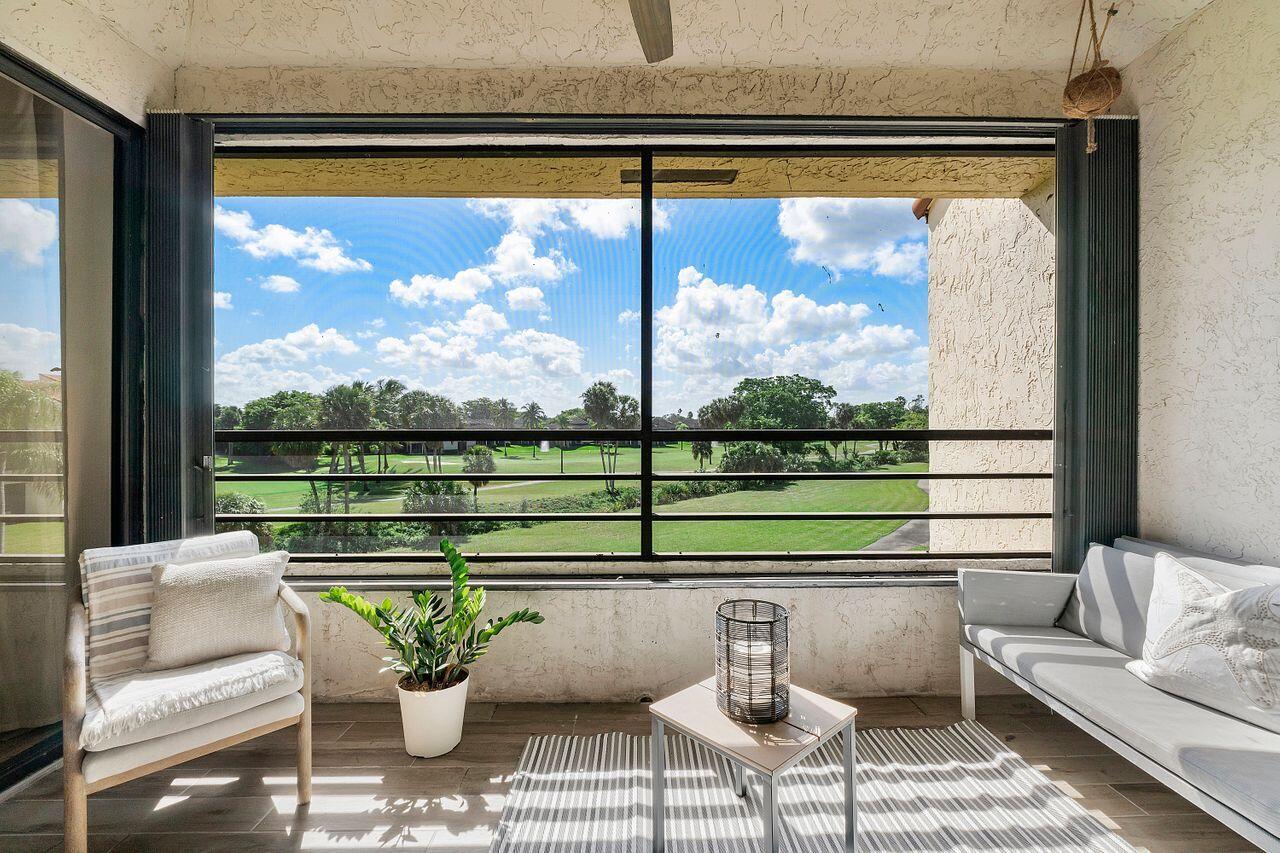 7508 La Paz Boulevard, Unit 304 Boca Raton, FL 33433 - Photo 25 of 44 a living room with a large window and a table