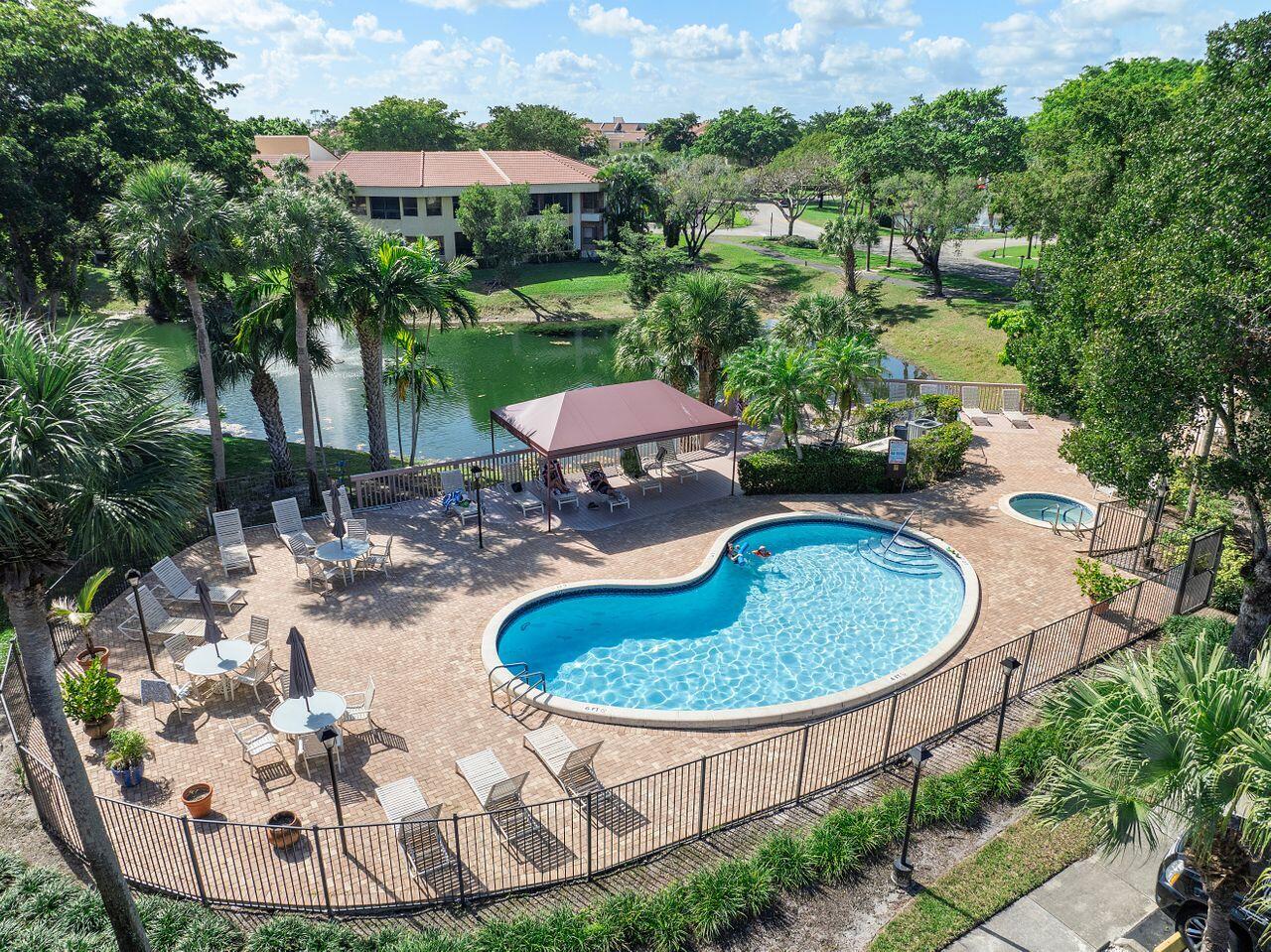 7508 La Paz Boulevard, Unit 304 Boca Raton, FL 33433 - Photo 31 of 44 a view of a swimming pool with a yard