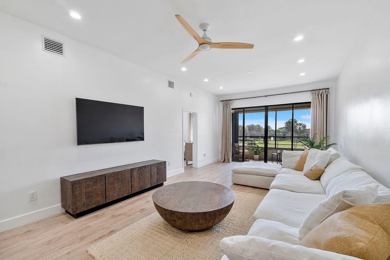 7508 La Paz Boulevard, Unit 304 Boca Raton, FL 33433 - Photo 6 of 44 a living room with furniture and a flat screen tv