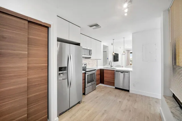 a kitchen with a refrigerator sink and cabinets