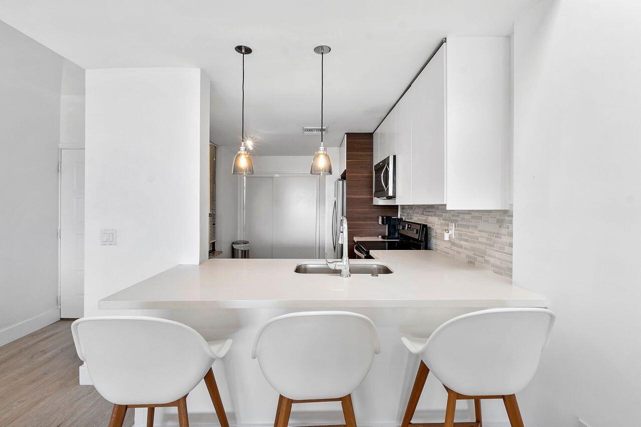 7508 La Paz Boulevard, Unit 304 Boca Raton, FL 33433 - Photo 9 of 44 a bathroom with a sink a chair and a mirror