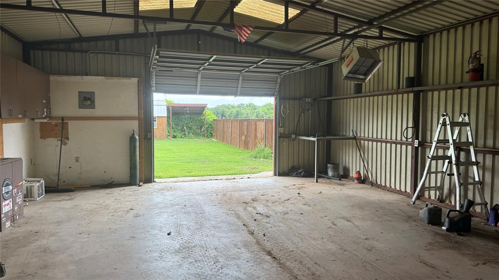 1356 Kerry Lane Azle, TX 76020 - Photo 27 of 27 Metal-sided workshop with an overhead roll-up door