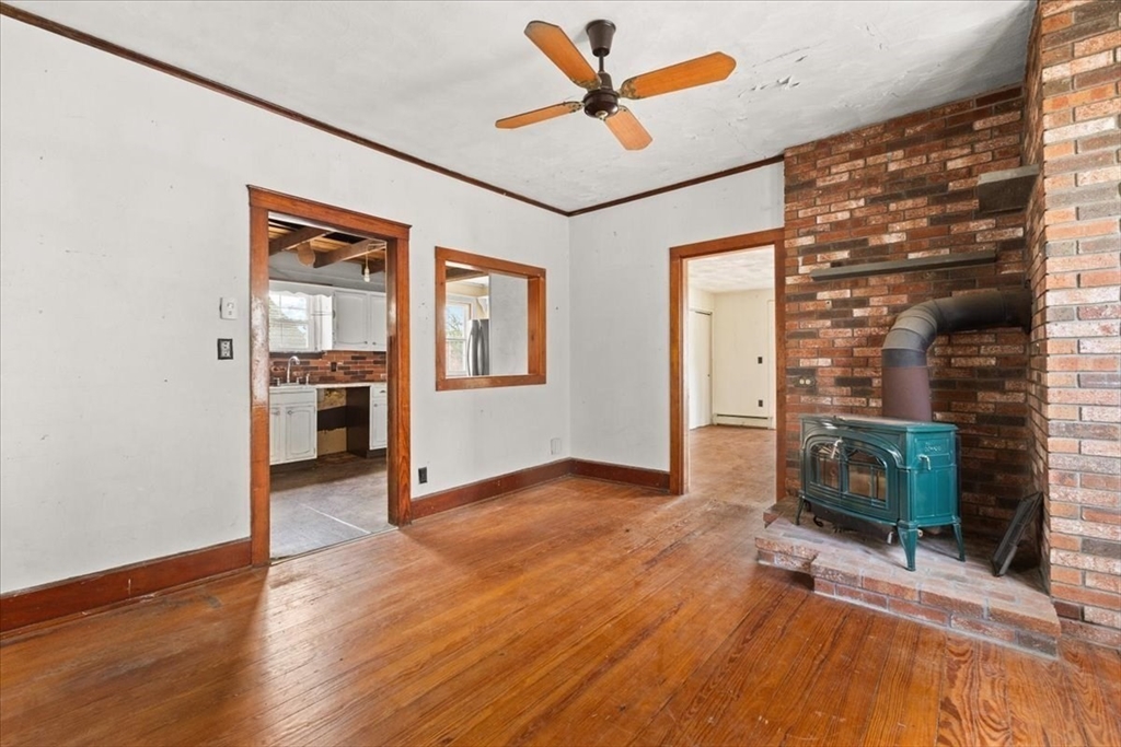 1496 Riverside Avenue Somerset, MA 02726 - Photo 18 of 40 an empty room with windows fireplace and a ceiling fan