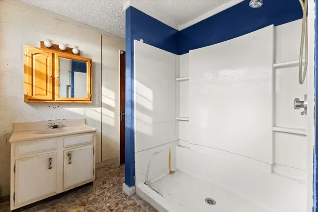 a bathroom with a shower and a sink a mirror