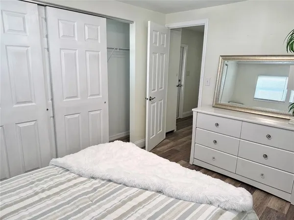 a bedroom with a large bed and a mirror on dresser