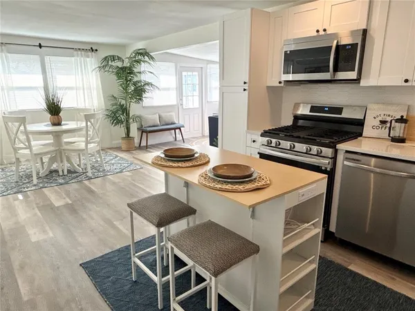 a kitchen with a stove and a wooden floor