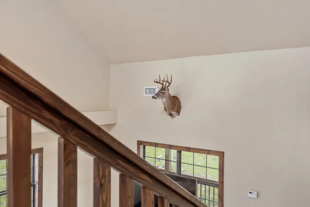 a view of a hallway with wooden floor and stairs