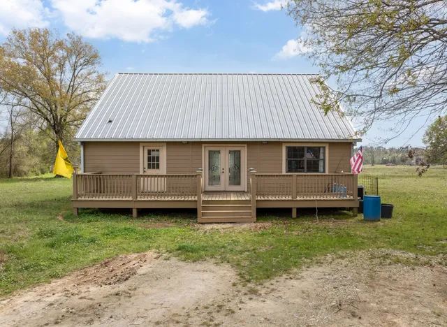 a front view of a house with a garden and deck