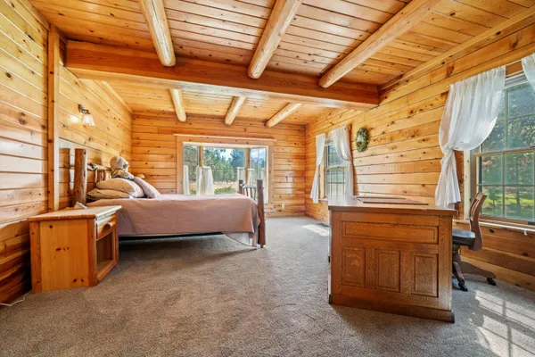 a bedroom with furniture and large windows