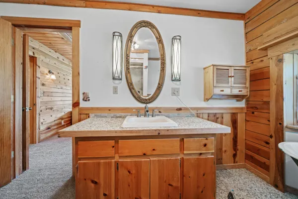 a bathroom with a granite countertop sink a mirror and a shower