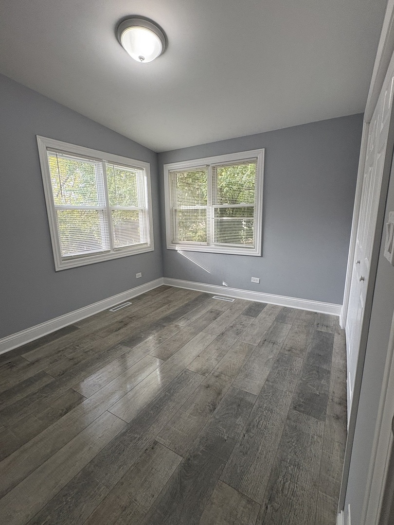 5517 Essex Road Lisle, IL 60532 - Photo 13 of 19 a view of an empty room with wooden floor and a window