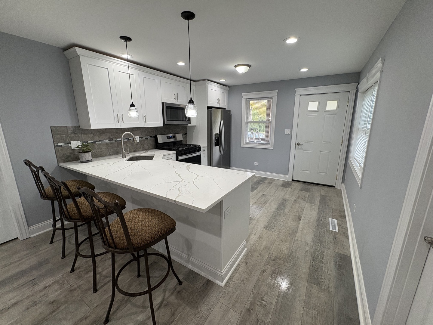 5517 Essex Road Lisle, IL 60532 - Photo 15 of 19 a kitchen with a table chairs refrigerator and microwave