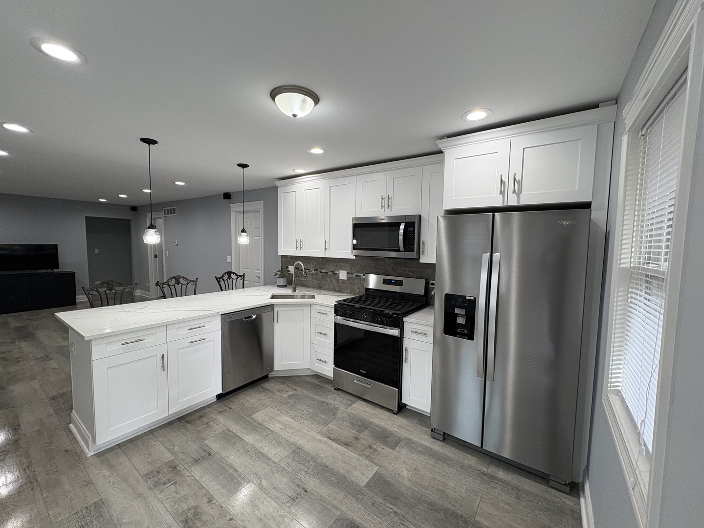 5517 Essex Road Lisle, IL 60532 - Photo 6 of 19 a kitchen with a refrigerator oven a sink dishwasher with a dining table and chairs