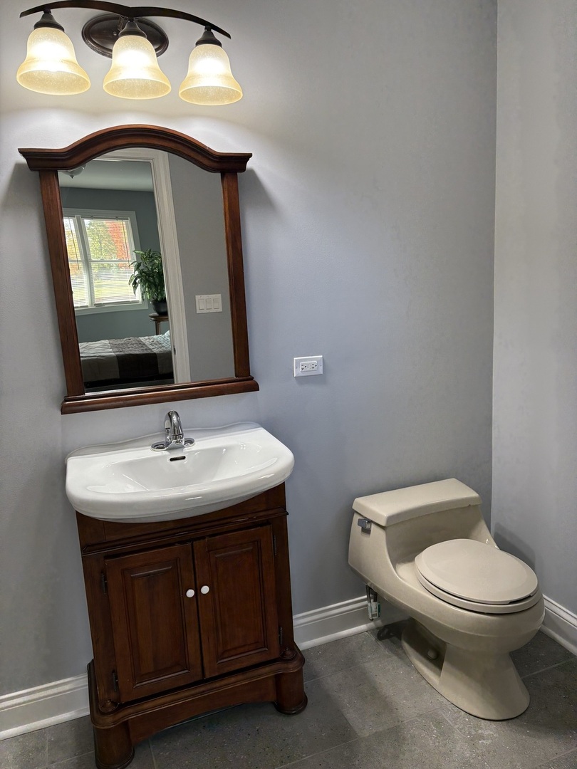 5517 Essex Road Lisle, IL 60532 - Photo 8 of 19 a bathroom with a toilet sink and mirror