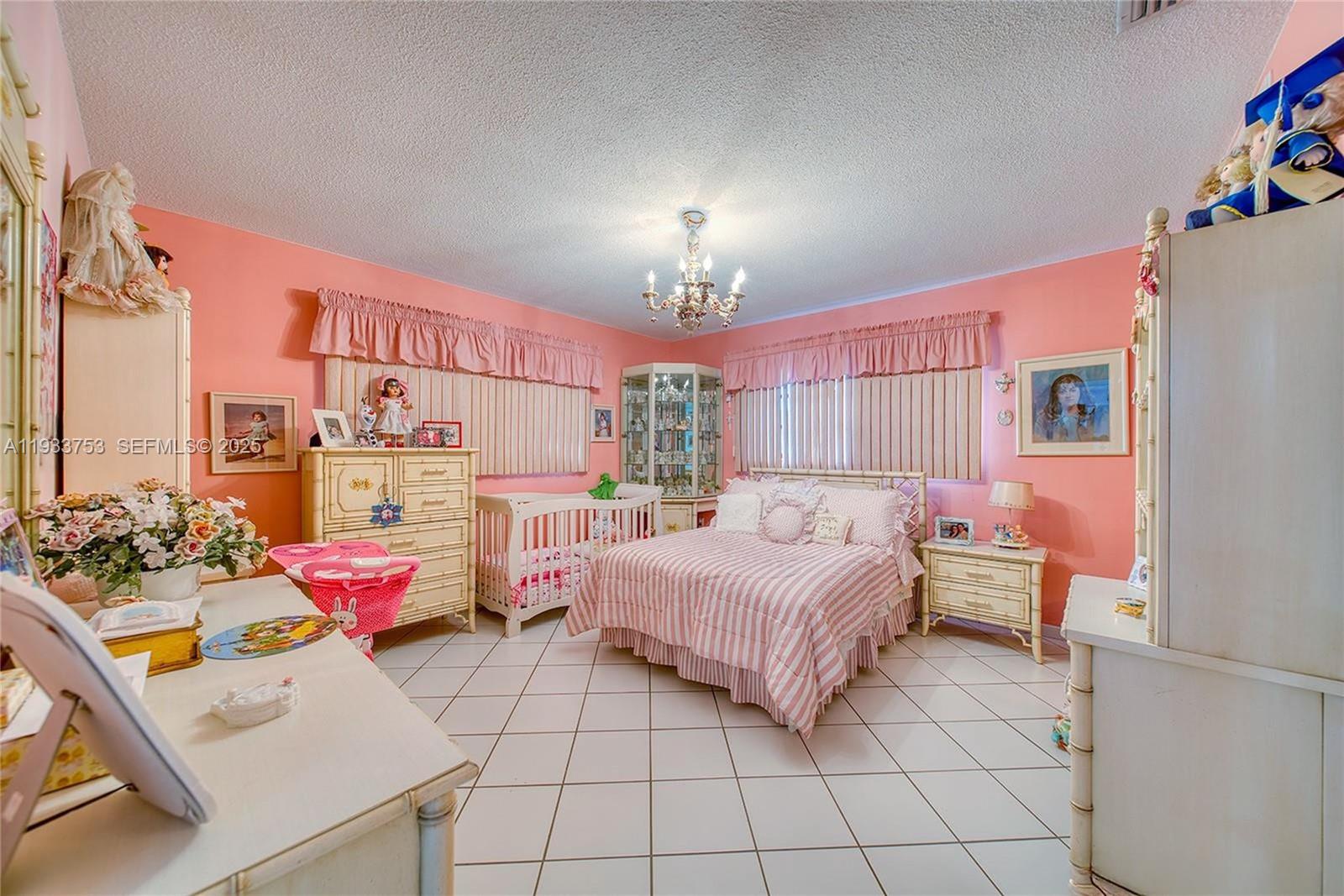 3585 Southwest 107th Court Miami, FL 33165 - Photo 18 of 45 a bedroom with bed and a chandelier