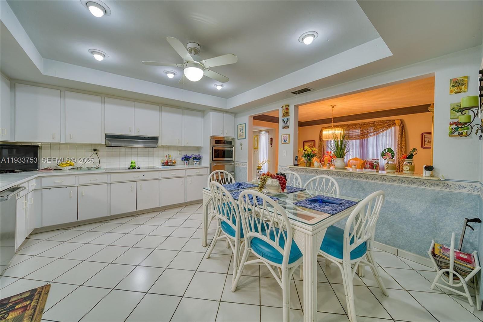 3585 Southwest 107th Court Miami, FL 33165 - Photo 31 of 45 a kitchen with stainless steel appliances a stove a sink a table and chairs