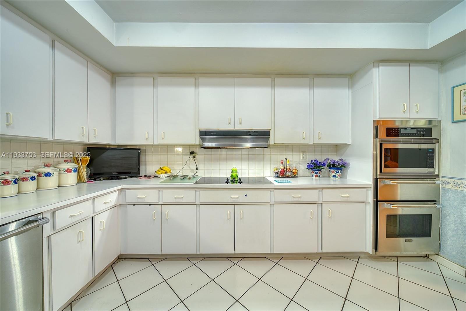 3585 Southwest 107th Court Miami, FL 33165 - Photo 32 of 45 a kitchen with granite countertop white cabinets and stainless steel appliances