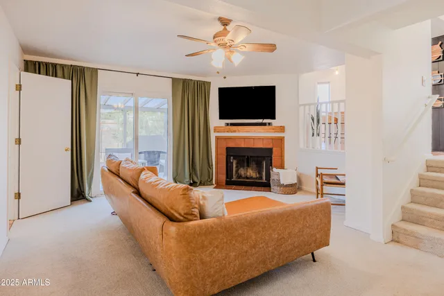 a living room with furniture a flat screen tv and a fireplace